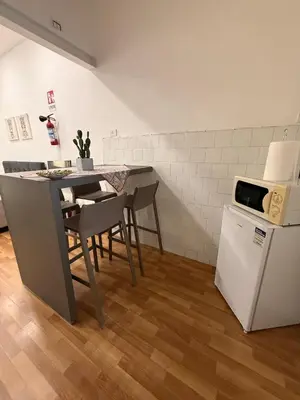 a kitchen with a table and a small refrigerator at Casetta Mape in Palermo