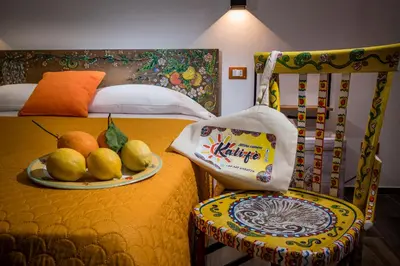 a hotel room with a plate of fruit on a bed at Kalifè Vacanze in Castellammare del Golfo