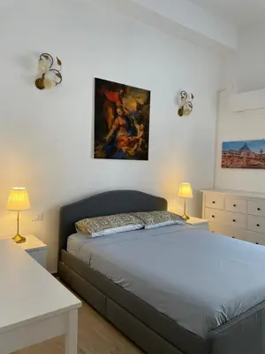 a bedroom with a bed and a painting on the wall at Casa in piazzetta in Balestrate