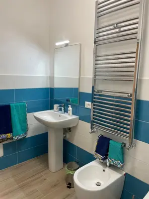 a blue and white bathroom with a sink and a toilet at Casa in piazzetta in Balestrate