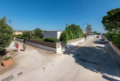 two people walking down a street next to a fence at Casa Vacanza Azzurra 2 in San Vito lo Capo