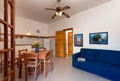 a living room with a blue couch and a table at Casa Vacanza Azzurra 2 in San Vito lo Capo