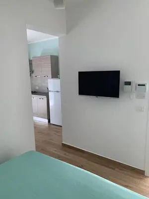 a living room with a tv on a white wall at Denise Vacanze - Monolocali arredati in Bagheria