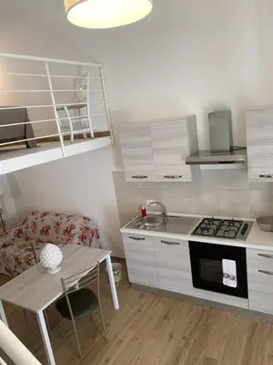 a small kitchen with a table and a stove at Denise Vacanze - Monolocali arredati in Bagheria
