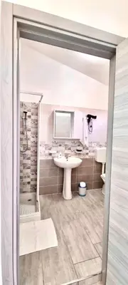 a white bathroom with a sink and a shower at B&B Torre Turrisi in Partinico