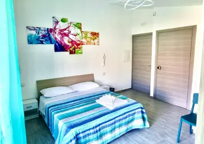 a bedroom with a bed with a blue and white blanket at B&B Torre Turrisi in Partinico