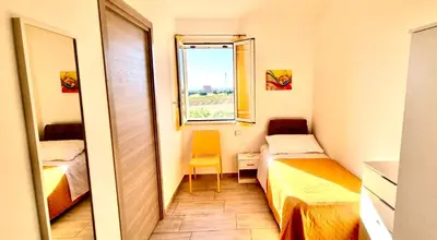 a small room with two beds and a window at B&B Torre Turrisi in Partinico