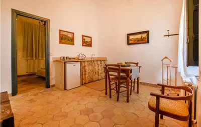 a kitchen with a refrigerator and a table and chairs at Acque Di Palermo in Roccapalumba