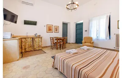 a room with a bed and a kitchen and a table at Acque Di Palermo in Roccapalumba