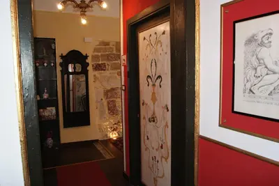 a hallway with red walls and a door with a mirror at BeeClaire Guest House in Palermo