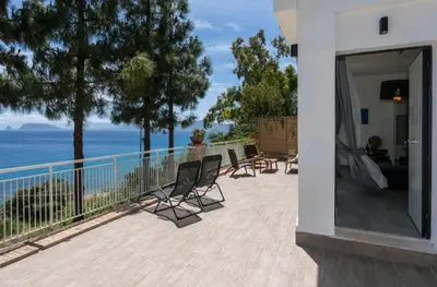 a balcony with chairs and a view of the ocean at Villa's apartment on the beach, swimming pool A/C in Palermo