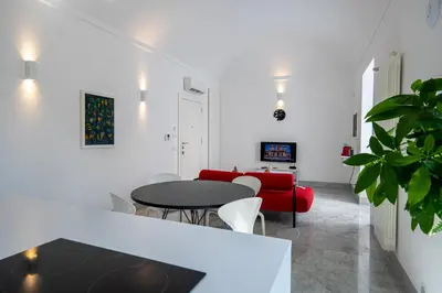 a living room with a table and a red couch at Suite Bellini 5 Apartment in Palermo