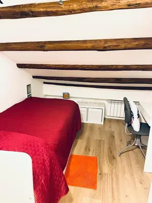 a bedroom with a red bed and a chair at Casa Levante in Isola delle Femmine