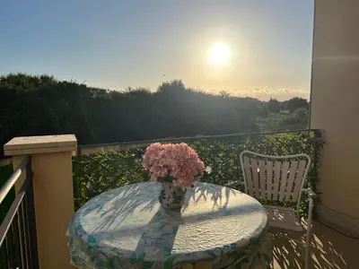 a vase of flowers sitting on a table on a balcony at Esmaraldas House of Love in Terrasini