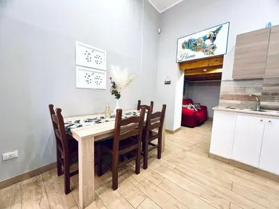 a kitchen and dining room with a table and chairs at Giglio Home in Palermo