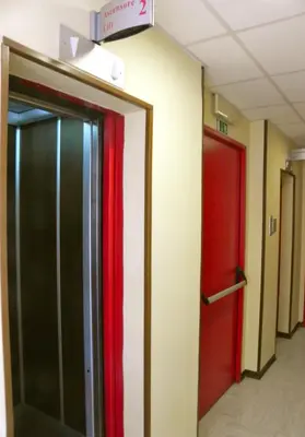 two elevators in a hallway with red and black doors at Torreata Hotel & Residence in Palermo