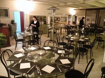 a woman standing in a room with tables and chairs at Torreata Hotel & Residence in Palermo