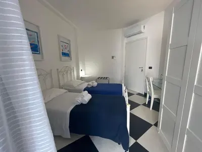 a small bedroom with two beds and a table at Casa Galati in Palermo