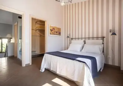 a bedroom with a bed with a blue and white blanket at Seaside Villa in Carini