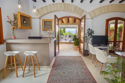 a kitchen and dining room with a counter and stools at Hotel La Tavernetta in Scopello