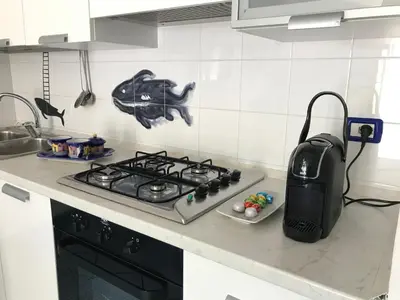 a kitchen counter with a stove and a sink at Casa Dorotea in Nuova Gibellina