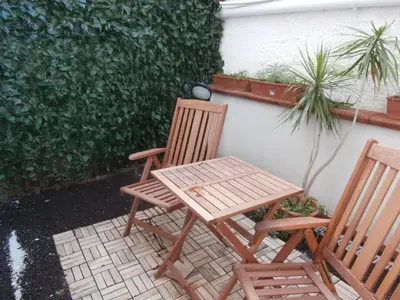 two chairs and a table and a table and a plant at Busalacchi B&B in Mondello