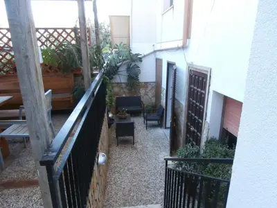 a balcony of a building with chairs and plants at Busalacchi B&B in Mondello