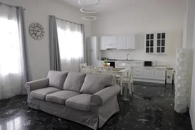 a living room with a couch and a table in a kitchen at Casa Costanzo in Capaci