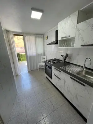 a white kitchen with a sink and a stove at Casa Cristy palermo in Palermo