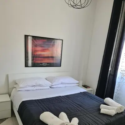 a bedroom with a bed with two white towels on it at Casa Cristy palermo in Palermo