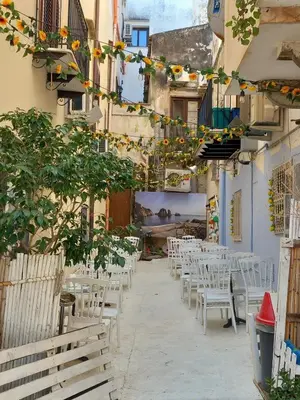 a row of tables and chairs in an alley at Le Plejadi in Castellammare del Golfo