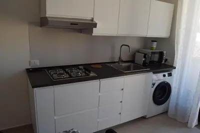 a kitchen with a sink and a stove and a washing machine at Domus Ponente in Terrasini