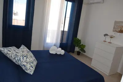 a bedroom with a blue bed with two pillows at Domus Ponente in Terrasini