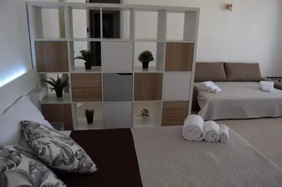 a bedroom with a bed and a couch and a shelf at Domus Ponente in Terrasini