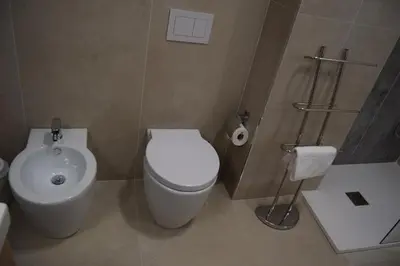 a bathroom with a white toilet and a sink at Domus Ponente in Terrasini