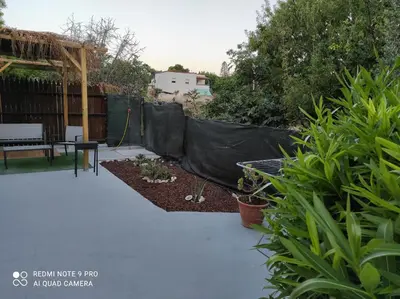a garden with a black tarp over a patio at Mondello sicily apartament in Mondello