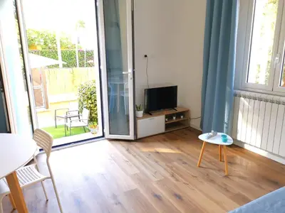 a living room with a television and a table and chairs at Mondello sicily apartament in Mondello
