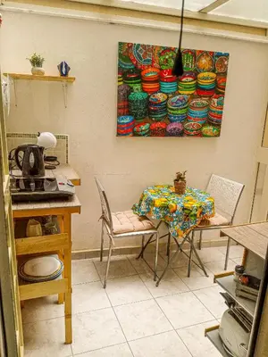a table and chairs in a kitchen with a painting on the wall at Casa Sedie Volanti in Palermo