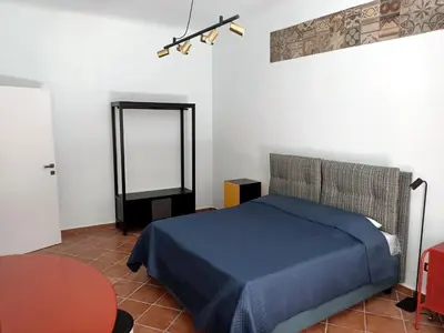 a bedroom with a blue bed and a mirror at Sofia Holiday Home in Palermo