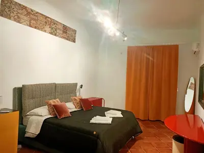 a bedroom with a bed and a orange curtain at Sofia Holiday Home in Palermo