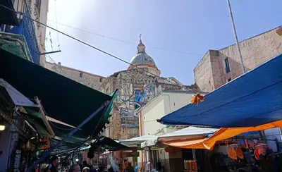 a street with a building with a tower in the background at Sofia Holiday Home in Palermo