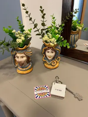 two vases with flowers in them on a table at Allegracori Appartamenti in Castellammare del Golfo