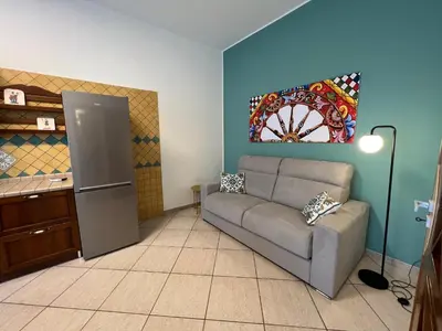 a living room with a couch and a refrigerator at Allegracori Appartamenti in Castellammare del Golfo