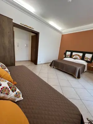 a bedroom with two beds and a tile floor at Allegracori Appartamenti in Castellammare del Golfo