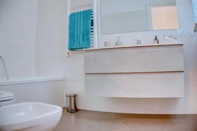 a white bathroom with a sink and a toilet at Villa Deluxe con Idromassaggio in Palermo