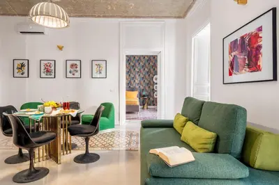 a living room with a green couch and a table at 124 Maqueda Apartments in Palermo