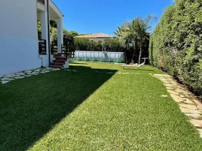 a yard with green grass next to a house at Villa Jari in Carini