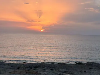 a sunset over the ocean with the sun setting at Villa Jari in Carini