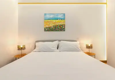 a bedroom with a white bed with two lamps at Casa Imperia in Palermo