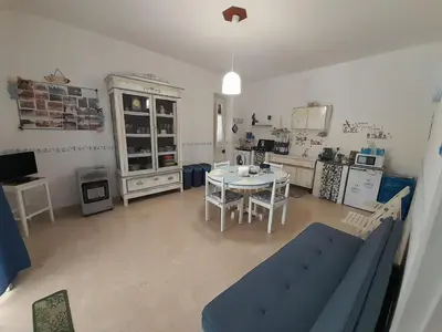 a living room with a table and a kitchen at Casa Vacanze Ciccinè in Capaci